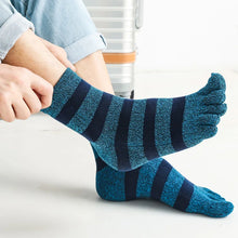 Load image into Gallery viewer, Blue striped toe socks worn by a person sitting on a white surface.