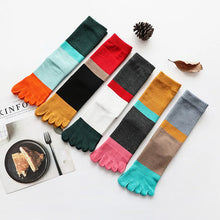 Load image into Gallery viewer, Colorful toe-shaped socks arranged on a white surface with a plate of food and newspaper.
