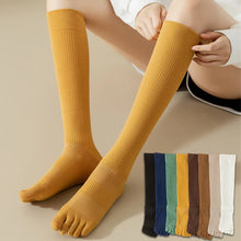 Load image into Gallery viewer, A pair of yellow knee-high socks with visible toe separation, displayed on a person's leg.