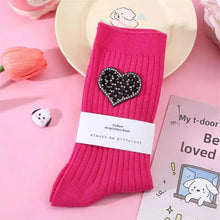 Load image into Gallery viewer, Pink sock with a heart-shaped embellishment on a pink background