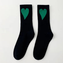 Load image into Gallery viewer, Black socks with green hearts on a white background