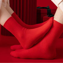 Load image into Gallery viewer, Red socks worn by a person on a red background