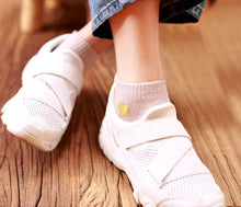 Load image into Gallery viewer, White sneakers with a heart design on socks on a wooden floor
