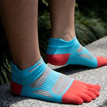 Load image into Gallery viewer, Five-toe socks with split toes on feet, standing on a rock with greenery in the background.
