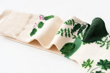 Load image into Gallery viewer, Folded fabric with green leaf pattern on a white background
